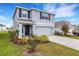 Two-story home featuring gray paint, a two-car garage, and colorful landscaping at 4231 Autumn Fog Ct, Palmetto, FL 34221