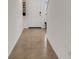 Hallway with neutral tile floors, white baseboards, and decor on wall leading to white front door at 4231 Autumn Fog Ct, Palmetto, FL 34221