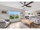 Cozy living room with neutral tones, a large window, a ceiling fan, and an open view to the kitchen at 4231 Autumn Fog Ct, Palmetto, FL 34221