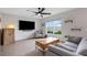 Bright living room featuring modern furniture, a mounted TV, and a large window with a view of the backyard at 4231 Autumn Fog Ct, Palmetto, FL 34221