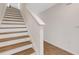 Clean staircase with wood treads and white risers, leading to the upper level of the home at 4231 Autumn Fog Ct, Palmetto, FL 34221