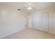 The bright bedroom has tiled flooring, a ceiling fan, and a closet with sliding doors for easy storage at 4296 Symco Ave, North Port, FL 34286