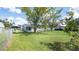 Large, grassy backyard with trees and a view of the home's rear at 4493 Mckibben Dr, North Port, FL 34287