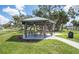A community gazebo surrounded by green grass and shady trees provides a relaxing outdoor space at 4493 Mckibben Dr, North Port, FL 34287