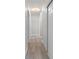 Long hallway with wood flooring, base trim, and doors at 4493 Mckibben Dr, North Port, FL 34287