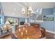 An elegant chandelier hangs over a wood dining table in a room with a stairway and view of the backyard at 4543 Forest Wood Trl # 33, Sarasota, FL 34241