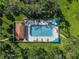 Aerial view of a sparkling pool surrounded by lush landscaping and mature trees at 4543 Forest Wood Trl # 33, Sarasota, FL 34241