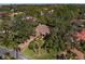 Aerial shot showcases a home nestled among mature trees with a long driveway and manicured lawn at 4701 Pine Harrier Dr, Sarasota, FL 34231