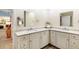 Bathroom featuring a double vanity with white cabinets and light countertops under two mirrors with modern fixtures at 4701 Pine Harrier Dr, Sarasota, FL 34231