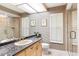 Bright bathroom featuring a granite-topped vanity, large mirror, toilet, and glass shower at 4701 Pine Harrier Dr, Sarasota, FL 34231