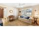 Cozy sitting room with a comfortable sofa, large window with shutters, and access to an en suite bathroom at 4701 Pine Harrier Dr, Sarasota, FL 34231