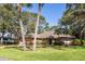 Charming single-story home with a tile roof, mature trees and a well-manicured lawn and a two car garage at 4701 Pine Harrier Dr, Sarasota, FL 34231
