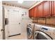 A spacious laundry room featuring modern front-load washer and dryer, and ample cabinet space at 4701 Pine Harrier Dr, Sarasota, FL 34231