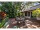 A quaint brick patio with lush tropical foliage and an outdoor seating area for relaxation at 4701 Pine Harrier Dr, Sarasota, FL 34231