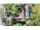 Aerial view from above highlighting the roof and caged pool of a home in a green, wooded community at 4965 Marsh Field Rd, Sarasota, FL 34235