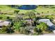 An aerial perspective reveals the house near a pond and golf course, surrounded by screened lanais at 4965 Marsh Field Rd, Sarasota, FL 34235