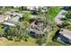 Aerial view from above highlighting the roof and caged pool of a home in a green, wooded community at 4965 Marsh Field Rd, Sarasota, FL 34235