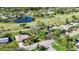 Aerial view of a golf course community showcasing a house with mature landscaping and a nearby pond at 4965 Marsh Field Rd, Sarasota, FL 34235
