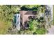 Aerial view from above highlighting the roof and caged pool of a home in a green, wooded community at 4965 Marsh Field Rd, Sarasota, FL 34235