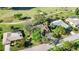An overhead shot of a home nestled within lush greenery and near a serene pond on a golf course at 4965 Marsh Field Rd, Sarasota, FL 34235