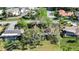 Aerial view from above highlighting the roof and caged pool of a home in a green, wooded community at 4965 Marsh Field Rd, Sarasota, FL 34235