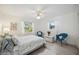 Bright bedroom features white walls, two windows, light wood floors and is decorated with two blue rattan chairs at 4965 Marsh Field Rd, Sarasota, FL 34235