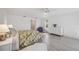 Bright bedroom with gray flooring, white walls, floral bedding, and a chair near the window at 4965 Marsh Field Rd, Sarasota, FL 34235
