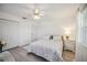Bright bedroom features white walls, a window with sheer curtains, and is decorated with patterned bedding and light wood floors at 4965 Marsh Field Rd, Sarasota, FL 34235