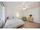 Bright bedroom with a light wood frame bed, white walls and curtains and a cozy green chair at 4965 Marsh Field Rd, Sarasota, FL 34235