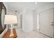 Bright entryway featuring white tile flooring and a stylish front door with sidelight windows at 4965 Marsh Field Rd, Sarasota, FL 34235