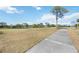 Scenic view of the golf course with a paved path, lush green grass, and a tranquil pond at 4965 Marsh Field Rd, Sarasota, FL 34235