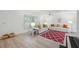Bright living room with white sofas, wood-look floors, and a patterned red rug at 4965 Marsh Field Rd, Sarasota, FL 34235