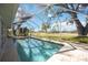 Screened in pool with a view of a beautiful green yard and mature trees at 4965 Marsh Field Rd, Sarasota, FL 34235