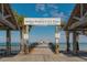 Anna Maria City Pier view with a wooden boardwalk extending into the ocean with palm trees at 5007 2Nd Ave, Holmes Beach, FL 34217