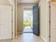 Inviting foyer featuring neutral-toned tile flooring, a blue front door, and views to the manicured front yard at 5011 Kincaid Park Ln, Bradenton, FL 34211