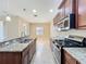 Open kitchen showcasing granite counters, stainless appliances, dark wood cabinetry, and tile flooring at 5011 Kincaid Park Ln, Bradenton, FL 34211
