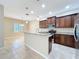 Modern kitchen with granite countertops, stainless steel appliances, dark wood cabinetry, and tile flooring at 5011 Kincaid Park Ln, Bradenton, FL 34211