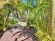Lush tropical landscaping and winding brick path in the backyard offer a tranquil outdoor escape at 5011 Kincaid Park Ln, Bradenton, FL 34211