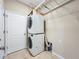 A functional laundry room equipped with a stacked washer and dryer and wire shelving at 5011 Kincaid Park Ln, Bradenton, FL 34211