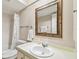 Well-lit bathroom features a vanity, framed mirror, and a shower-tub combination with a curtain at 5117 27Th W St # 5117, Bradenton, FL 34207