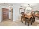 Dining area with a wooden table, decorative mirror, and a wooden front door entrance with tiled floors at 5117 27Th W St # 5117, Bradenton, FL 34207