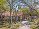 Front exterior view of a home surrounded by mature trees, lush landscaping, and a covered carport at 5117 27Th W St # 5117, Bradenton, FL 34207
