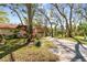 Home exterior with mature landscaping, trees, neutral paint, a carport, and a long driveway at 5117 27Th W St # 5117, Bradenton, FL 34207