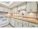 Bright kitchen features wooden countertops, white cabinets, and a double basin sink with natural light at 5117 27Th W St # 5117, Bradenton, FL 34207