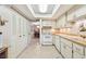 The bright kitchen has tile floors, white appliances, and ample cabinet storage space and wooden shelves at 5117 27Th W St # 5117, Bradenton, FL 34207
