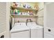 A well-organized laundry closet features shelving for supplies and a full-sized washer and dryer for added convenience at 5117 27Th W St # 5117, Bradenton, FL 34207