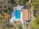Aerial view of a community pool with lounge chairs, lush greenery, and a clubhouse at 5117 27Th W St # 5117, Bradenton, FL 34207