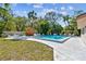 Community pool with chairs and umbrellas surrounded by lush tropical landscaping at 5117 27Th W St # 5117, Bradenton, FL 34207