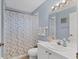 Bright bathroom with a patterned shower curtain and white vanity at 5240 Hyland Hills Ave # 1426, Sarasota, FL 34241