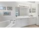 All-white bathroom features a bathtub, vanity, and framed art at 5240 Hyland Hills Ave # 1426, Sarasota, FL 34241